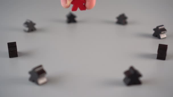 Рука Устанавливает Красную Фигуру Окружённую Черными Фигурами Серой Поверхности Лидер — стоковое видео