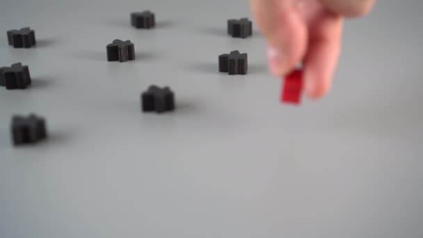 Een Hand Wordt Een Rode Figuur Omringd Door Zwarte Figuren — Stockvideo