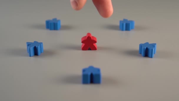 手は灰色の表面の青い形の周囲から赤い形を取り除きます チームからリーダーを解雇するという概念 — ストック動画
