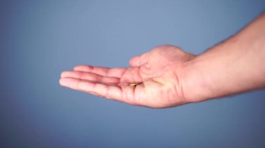 Sikkeler mavi bir arka plan üzerinde bir elde düşmek. İş hayatında iyi şans ve profesyonellik kavramı