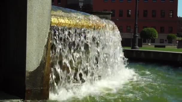 Een Stroom Van Water Overstroomt Gouden Barrière Fontein Een Zonnige — Stockvideo