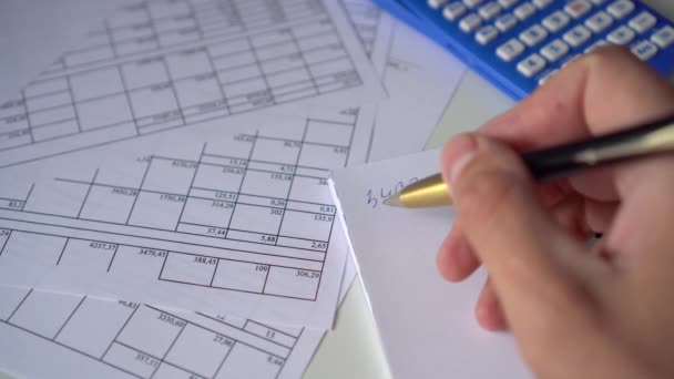 Een Tafel Met Papieren Financiële Rekeningen Een Calculator Hand Van — Stockvideo
