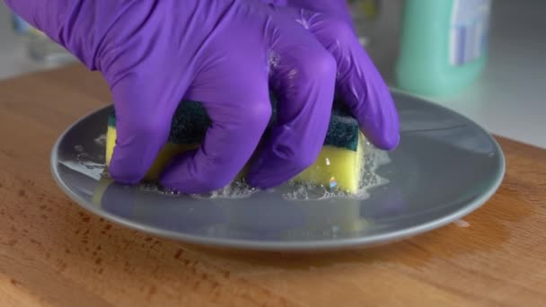 一只戴着蓝色防护手套的手挤着一块黄绿色的海绵 泡沫气泡并排入灰色板上 慢动作 带优质洗涤剂的客房管理 — 图库视频影像