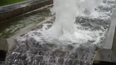 Köpüklü su akıntıları yükselir ve düşer. Şehir parkındaki çeşmeler sokağı. Yavaş çekim