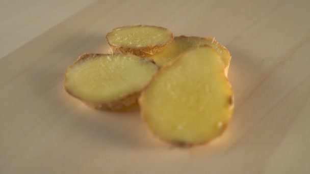 木製の表面に生姜の根スピンのジューシーな熟したスライス 自然で健康的な製品から自家製の食事料理の準備 — ストック動画