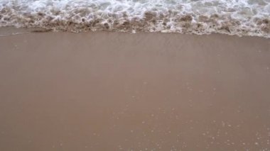 Sakin akşam okyanus sörfü. Köpüklü dalgalar kumlu plajı doldurur. Sakinlik ve pasifizasyon kavramı