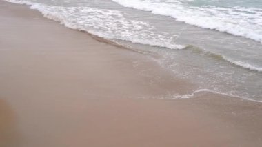 Sakin akşam okyanus sörfü. Köpüklü dalgalar kumlu plajı doldurur. Sakinlik ve pasifizasyon kavramı