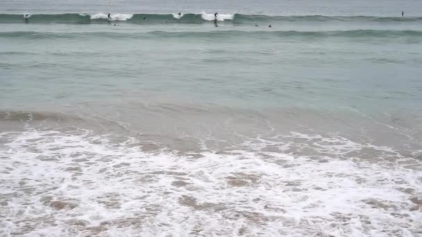 Wieczór Ocean Surf Pieniaste Fale Wypełniają Piaszczystą Plażę Surfers Okrakiem — Wideo stockowe