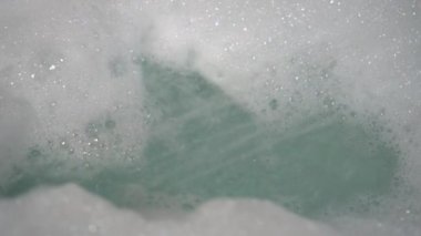 Duştan gelen bir su akışı küvete bir demet köpük siler. Kabarcıklar oluşur ve düşer. Hijyen ürünlerinin kullanımı