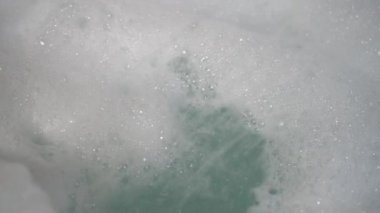 Duştan gelen bir su akışı küvete bir demet köpük siler. Kabarcıklar oluşur ve düşer. Hijyen ürünlerinin kullanımı