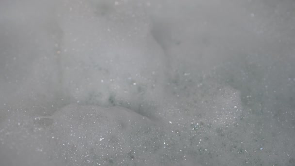 ティーンエイジャーは 浴槽から新鮮な泡の束を熊手とピックアップ 光の中で泡が光る — ストック動画