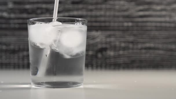 Een Wit Drinkbaar Bad Roert Water Met Ijsblokjes Een Glazen — Stockvideo