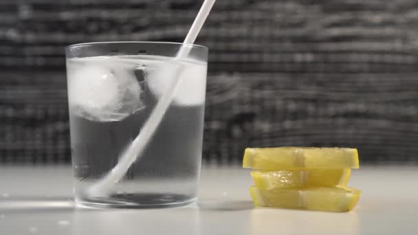 Eine Tube Wasser Und Eis Einem Gedämpften Glas Auf Schwarz — Stockvideo