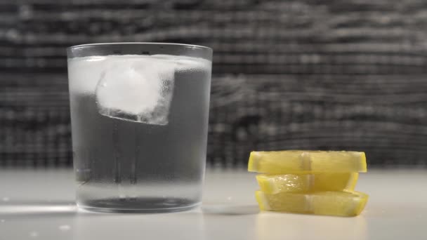 Eine Tube Wasser Und Eis Einem Gedämpften Glas Auf Schwarz — Stockvideo