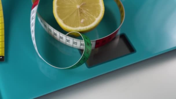 在海蓝宝石地板秤上 有五颜六色的厘米和半颗新鲜的柠檬 健康食品和体重管理工具 — 图库视频影像