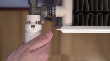 El oda ısıtma sıcaklığını azaltmak için beyaz ısıtma radyatör termostat döner. Mavi duvarlar ve kahverengi parke