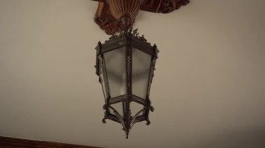 Beyaz tavanüzerinde antik ferforje desenli lamba