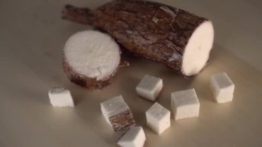 Ahşap bir mutfak tahtası üzerinde dilimlenmiş yucca kökü. Şifa Egzotik Malzemeler