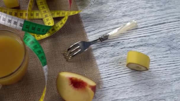 桃子、果汁和叉子放在麻布和一张带厘米的木桌上 — 图库视频影像