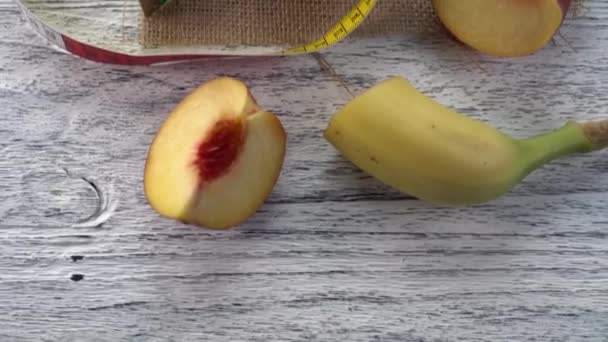 桃子，果汁在玻璃杯里，叉子放在麻布和一张带厘米的木桌上 — 图库视频影像