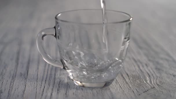 Agua Caliente Vierte Una Taza Vidrio Vacía Sobre Una Mesa — Vídeo de stock