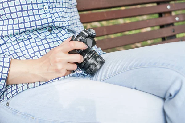 Câmera antiga nas mãos de uma menina de jeans azul e uma camisa azul — Fotografia de Stock