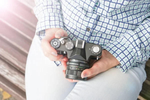 Câmera antiga nas mãos de uma menina de jeans azul e uma camisa azul — Fotografia de Stock