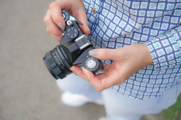 Дівчина в джинсах і сорочка з кінокамерою в руках у парку — стокове фото