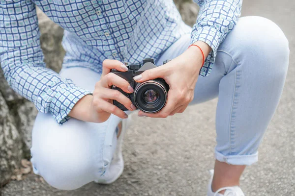 女孩穿着牛仔裤和衬衫，手里拿着电影相机在公园里 — 图库照片