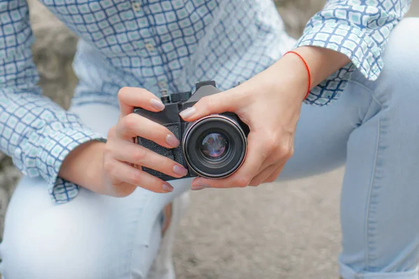 Uma menina de camisa azul segura uma câmera antiga — Fotografia de Stock