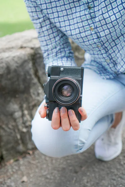 Mavi gömlekli bir kız antika bir kamera tutar — Stok fotoğraf