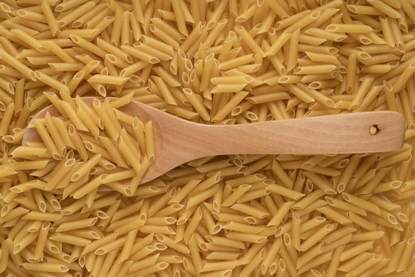 Una cucharada de madera está en un montón de pasta de trigo —  Fotos de Stock