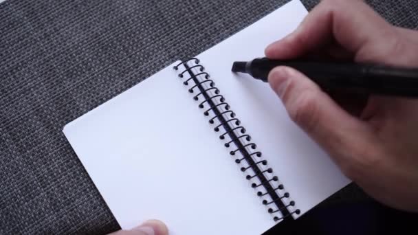 Ένα Αρσενικό Χέρι Γράφει Στόχοι Ένα Σημειωματάριο Μια Γκρίζα Επιφάνεια — Αρχείο Βίντεο