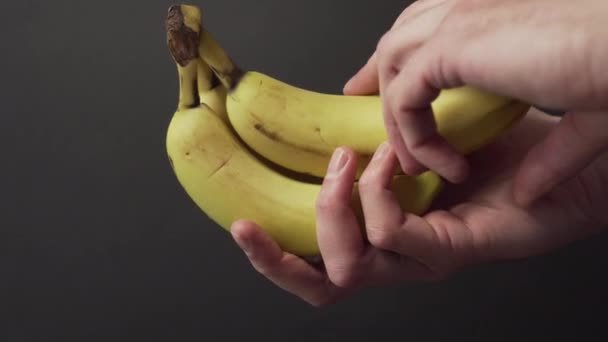 Ręka Odłamuje Banana Dojrzałego Owocu Ciemnym Tle Koncepcja Diety Zbiorów — Wideo stockowe