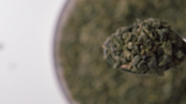 De la poudre de thé vert. Feuilles laminées séchées dans une cuillère en métal gros plan. Macro shot. Concentration sélective. Boisson traditionnelle chinoise aromatisée 