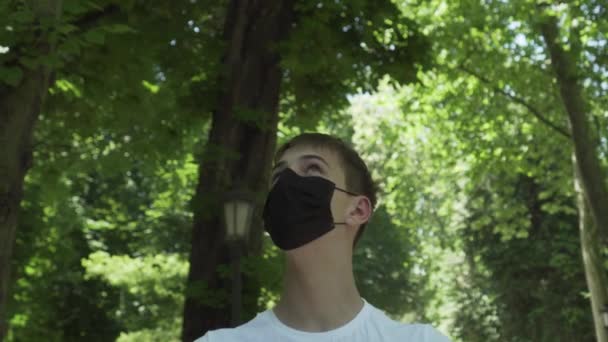 Fiatal Férfi Orvosi Védő Fekete Maszkban Egy Erdőben Zöld Lombozattal — Stock videók