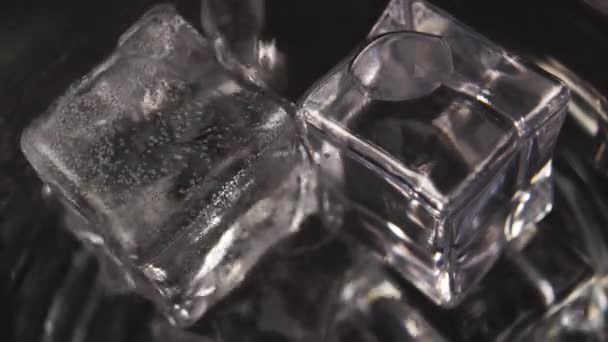 炭酸ミネラルウォーターをガラスの中の氷のキューブに注ぎ 多くの輝く泡がクローズアップされます マクロショット — ストック動画