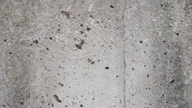 Eskimiş gri bir yüzeyi olan beton, eski bir duvar. Kamera kaydı. Yakın plan.