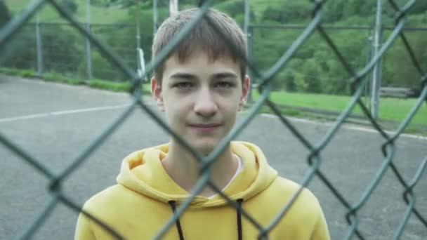 Joven Está Poniendo Una Máscara Médica Detrás Una Reja Hierro — Vídeo de stock