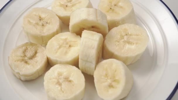 Skivad Banannärbild Färska Mogna Skivor Vit Platta Med Blå Kant — Stockvideo