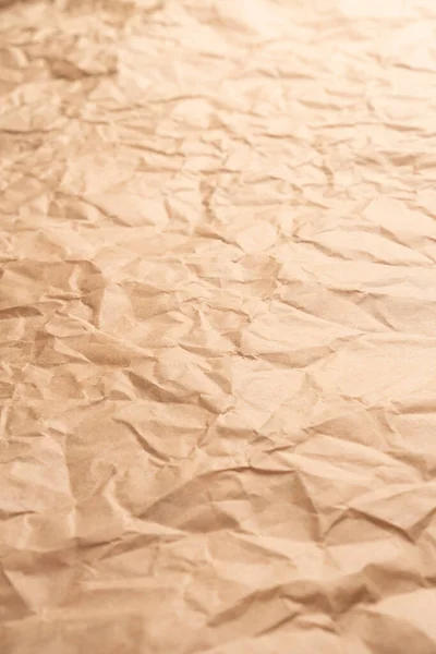 Crumpled brown creased paper. Old wrapping dusty paper. Delivery concept. Selective focus. Vertical view