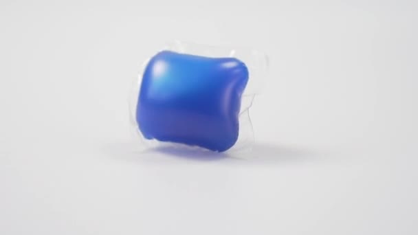 Kapsułka Niebieskim Żelem Zmywarki Spada Białe Tło Zbliżenie Domowy Środek — Wideo stockowe