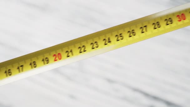 明亮的黄色金属测量带在轻型木制背景上的特写 测量工具 — 图库视频影像