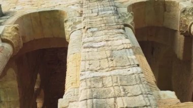 Eski İspanyol kilisesi. Kemerli camları ve desenli sütunları olan bir cephe. Duvarda yıkılmış duvarlar var. Antika mimari