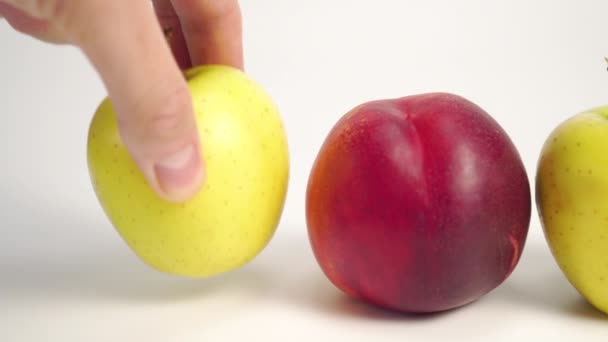 Ręka Kładzie Dojrzałe Jabłko Białym Stole Czerwoną Nektarynką Koncepcja Wyboru — Wideo stockowe