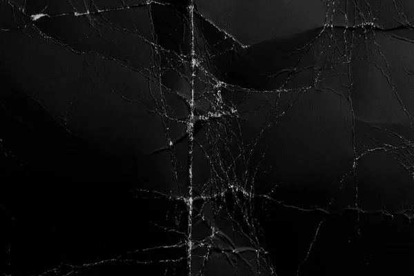 Buruşmuş kağıttan eskimiş siyah arkaplan. Kırışıklıklar ve toz ile eski hasarlı yüzey. Katlanmış karton