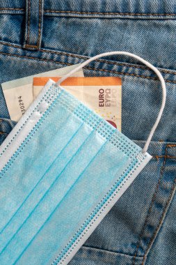 Avrupa banknotları ve mavi kotlara yakın plan tıbbi maske. İşsizlik ve koronavirüs salgını fikri