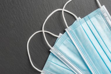 Gri taş arka planda tıbbi maskeler. Mavi tek kullanımlık güvenlik maskeleri. Coronavirus önleme ve koruma tedbirleri