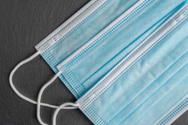Gri taş arka planda tıbbi maskeler. Mavi tek kullanımlık güvenlik maskeleri. Coronavirus önleme ve koruma tedbirleri
