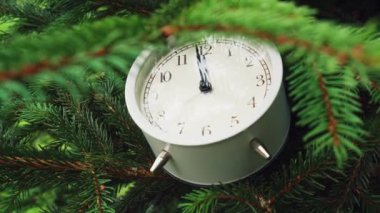 Üzerinde analog beyaz alarm saati olan bir Noel ağacı. Rüzgarda sallanıyor. Noel ve Yeni Yıl Arifesi ve Kutlama Kavramı